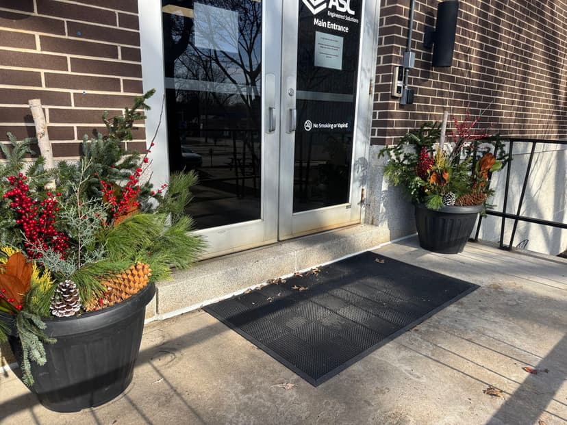 Entrance with seasonal decorative planters featuring pinecones, red berries, and greenery.